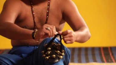 Kathakali dansçısı, gösteri için hazırlanırken ghungroo 'yu bağlıyor.. 
