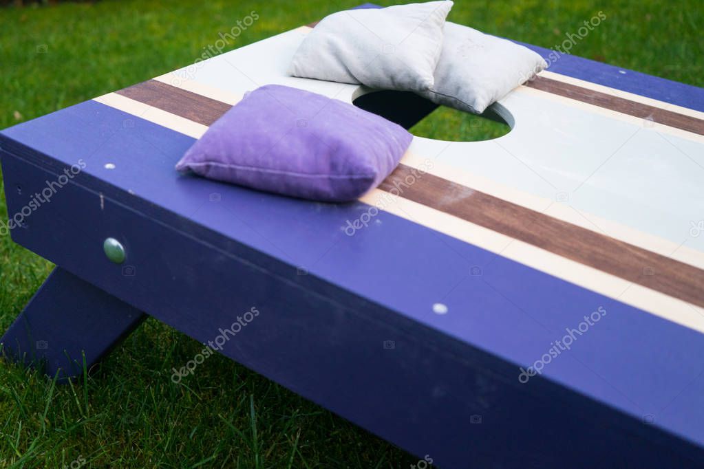 Cornhole beanbag toss wood game board outside on grass