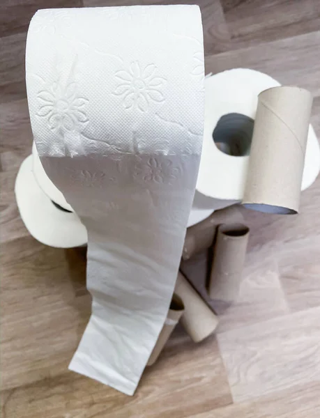 Stacks of empty and full white toilet paper rolls