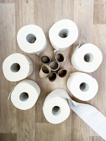 Stacks of empty and full white toilet paper rolls