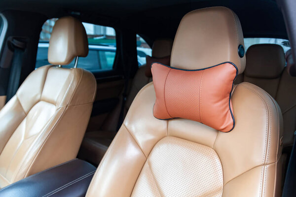 The seats in the car are made of brown leather with pillows for 