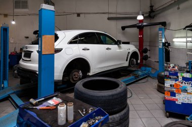 White used car Infiniti QX70 FX stands on the stand wheel alignm