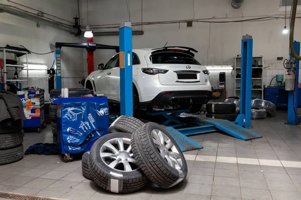 Coche usado blanco Infiniti QX70 FX se encuentra en el alineador de la rueda del soporte — Foto de Stock