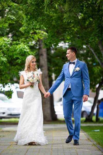 Joven hermosa pareja de recién casados novia y novio caminar sosteniendo — Foto de Stock