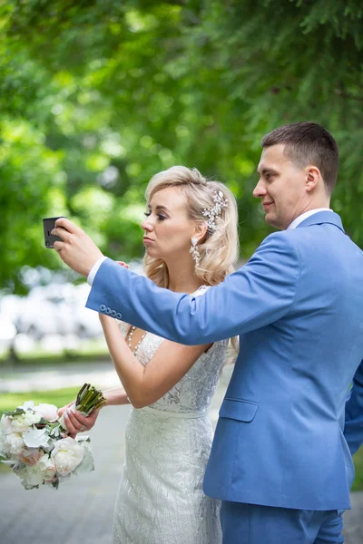 Giovane bella coppia di sposi novelli sposa e sposo a piedi in un pa — Foto Stock