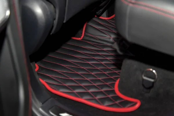 Elmas kırmızısı dikişli temiz siyah deri araba paspasları. — Stok fotoğraf