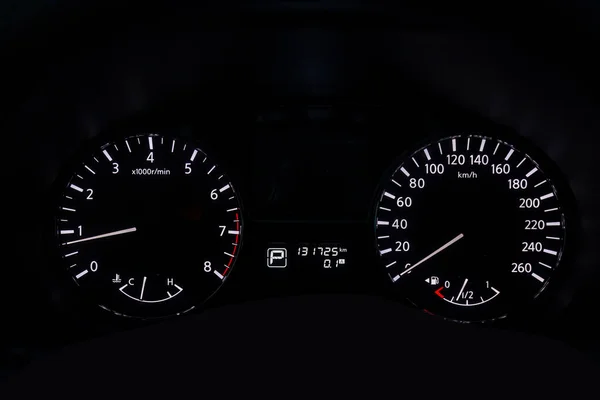 The dashboard of the car is glowing white with arrows at night w