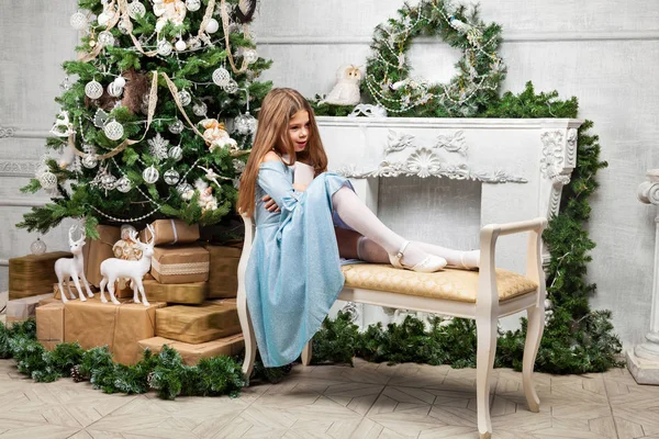 Petite jolie fille mignonne un banc près du sapin de Noël et f — Photo