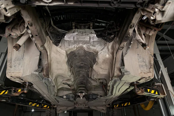 The bottom of the car lifted on a hydraulic lift during overhaul — Stock Photo, Image