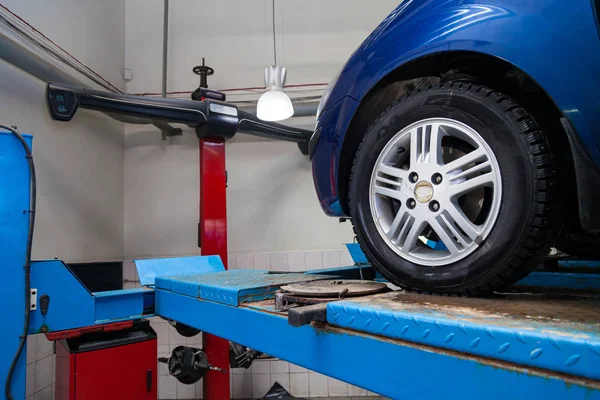 Μπλε αυτοκίνητο εμπρόσθια όψη τροχού στέκεται στο πόδι ευθυγράμμιση τροχού co — Φωτογραφία Αρχείου