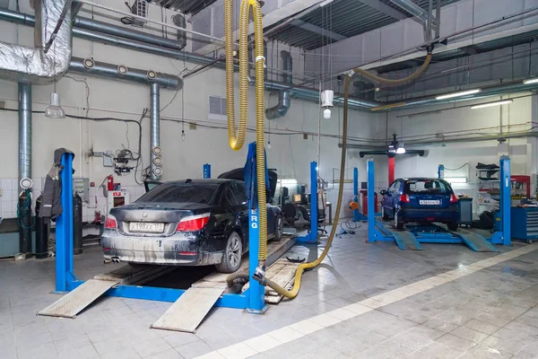 To brukte biler BMW med åpen hette hevet på heis for reparasjon – stockfoto