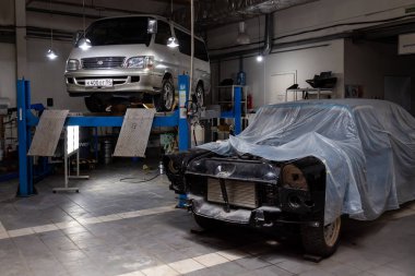 Beyaz kullanılmış Toyota Hiace minibüsü tamir için kaldırılmış. 