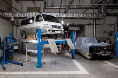 Beyaz kullanılmış Toyota Hiace minibüsü tamir için kaldırılmış. 