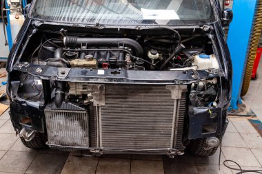 Atölyedeki parçalanmış siyah araba tamir için hazırlandı.