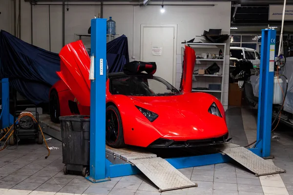 赤いスポーツカーマロシアB1は、車の修理店でリフトに上げました — ストック写真