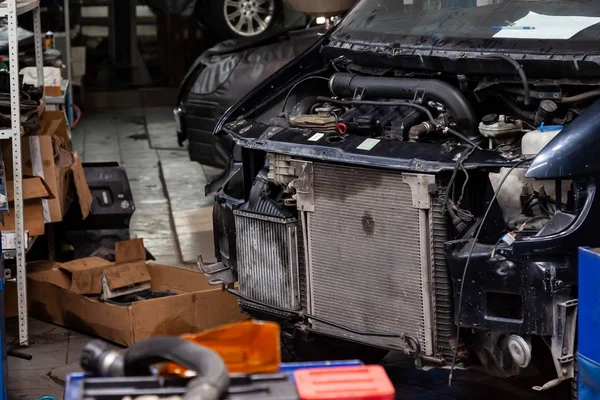 Gedemonteerde zwarte auto in de werkplaats klaar voor reparatie: fron — Stockfoto