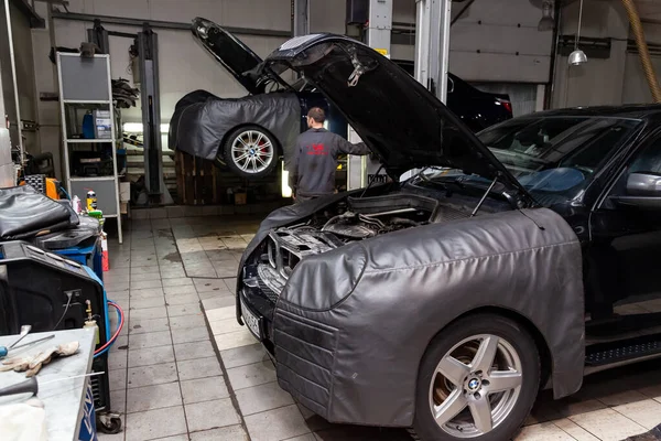 Carro preto desmontado com capuz openo na oficina levantada em — Fotografia de Stock