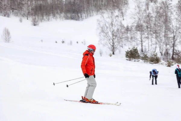 Een man skiër glijdt van de berg over witte sneeuw in een sport — Stockfoto