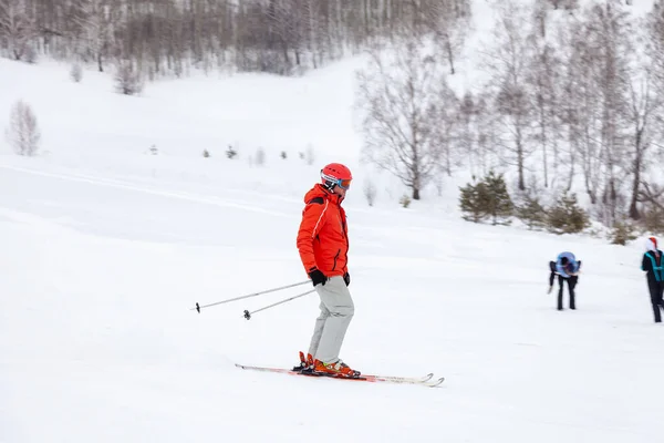 A man skier slides down the mountain over white snow in a sports — 스톡 사진