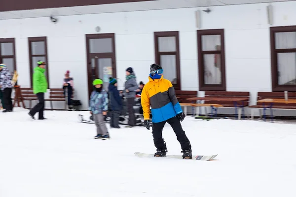 Muž snowboardista sklouzne z hory přes bílý sníh — Stock fotografie