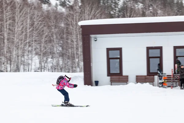 Дитячий лижник ковзає по горі над білим снігом в — стокове фото