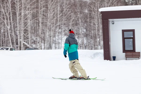 A man skier slides down the mountain over white snow in a sports — 스톡 사진