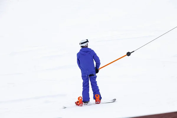 A man skier climbs a mountain through the white snow clinging to — 스톡 사진