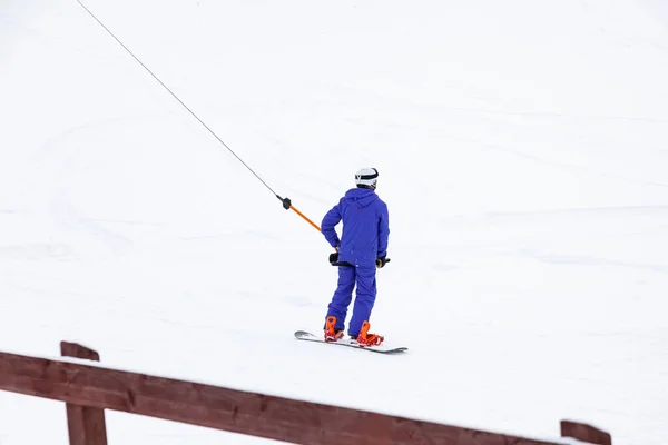A man skier climbs a mountain through the white snow clinging to — 스톡 사진