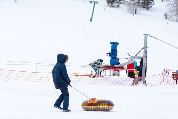 A young boy is having fun and riding from the mountain in the sn — ストック写真