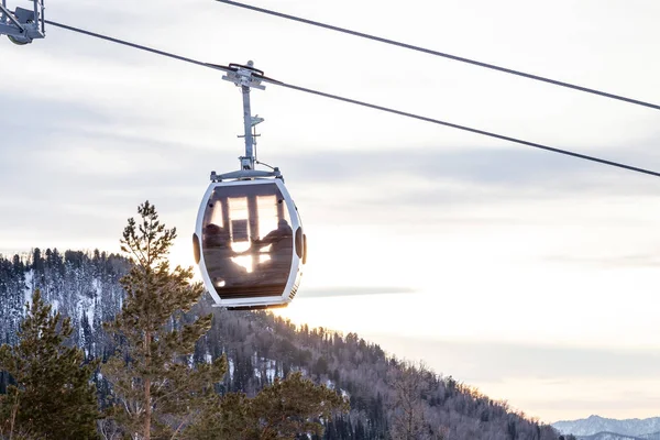 Egy gondola kötélpálya egy fülkével felfüggesztett egy kábelen, amelyben si — Stock Fotó