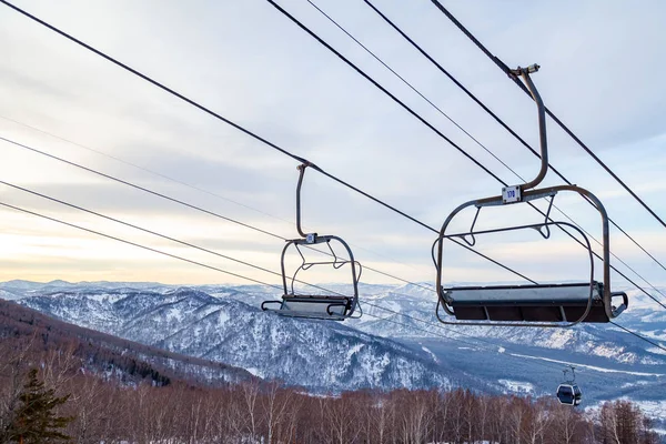 A ski lift chair cableway with a booth suspended on a cable in w