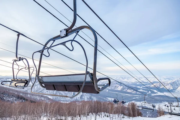 A ski lift chair cableway with a booth suspended on a cable in w — Stock Photo, Image