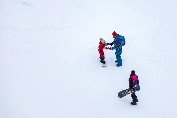 Чоловік, який не виказує сноуборду, пояснює дівчині, як снігопад. — стокове фото