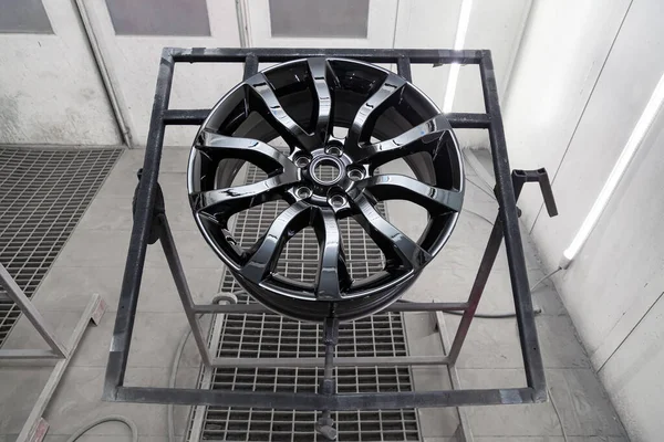Uma roda de liga de alumínio pintada de preto é montada em um fra especial — Fotografia de Stock