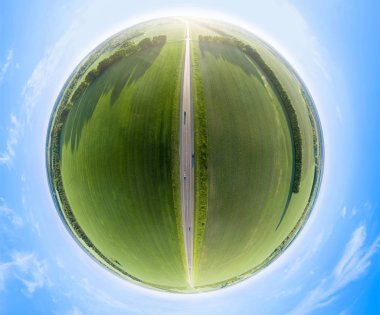 Mavi gökyüzünün altındaki yeşil tarlaların havadan görünüşü.