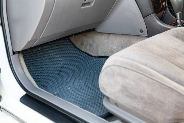 Tapetes de piso de carro limpo de borracha preta sob assento de passageiro no — Fotografia de Stock