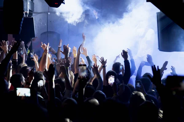 Publikum mit erhobenen Händen bei einem Musikfestival mit buntem Licht — Stockfoto