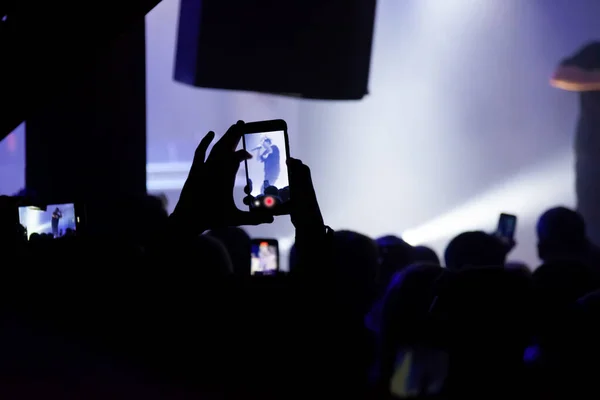 Hand mit einem Smartphone nimmt Live-Musik-Festival auf und fotografiert — Stockfoto