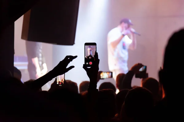 Ręka z płytami smartfona festiwal muzyki na żywo, robienie zdjęć — Zdjęcie stockowe