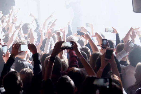 Publiczność z podniesionymi dłońmi na festiwalu muzycznym z kolorowymi ligh — Zdjęcie stockowe