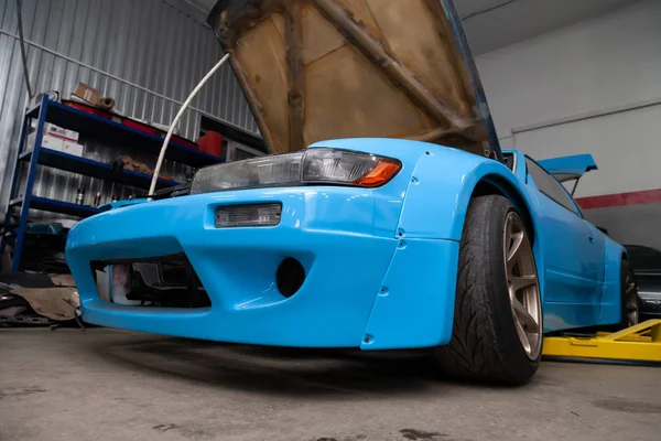 Мощный тюнингованный синий спорткар с открытым капотом и мощным двигателем — стоковое фото