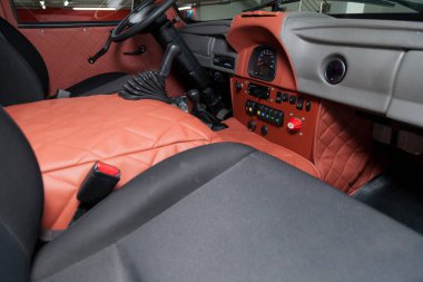 Novosibirsk, Russia - 02.26.2020: Red interior of used UAZ VAN 452 469 car with dashboard, steering wheel, and front seats prepared for off road drive