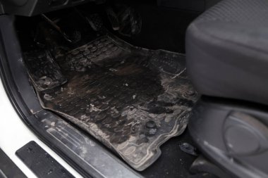 Kirli araba paspasları. Kuru temizlemeden önce atölyede gaz pedalları ve frenleri olan siyah lastik paspaslar. Otomobil servis endüstrisi. Sedan 'ın içi..