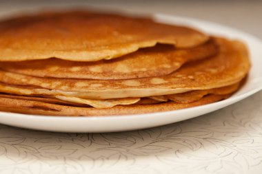 Evde kahvaltıda bir kap süt, un ve yumurta içinde pişirilmiş lezzetli ve taze krep yığını. Rus ulusal bayramı Shrovetide.