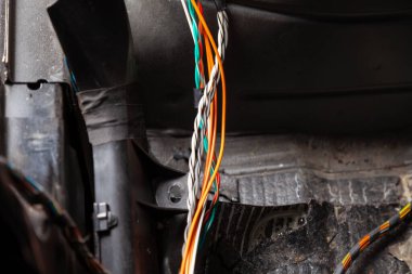 Kablo tamirhanesinde çok renkli turuncu ve yeşil kablolar, konnektörler ve terminaller bulunan geniş kablo ve elektrikçiler arabaya elektrik ve dijital sinyal bağlamak ve iletmek için