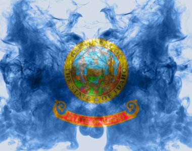 ABD devlet Idaho Ulusal bayrağı mavi kırmızı ve sarı farklı renklerde bağımsızlık gününde gri bir duman karşı. Politik ve dini anlaşmazlıklar, gümrük ve teslimat.