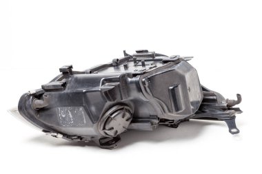 Beyaz arka planda siyah plastik yedek parça otomobil - içinde kapalı kapaklı ksenon far. Araç tamiri için araç gereçleri.