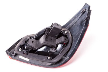 Siyah plastikten yapılmış fren lambasının arka farları, bir fotoğraf stüdyosunun beyaz izole arka planına monte edilmiş. Atölyedeki arka vagonun satışı ve onarımı için yedek parça..