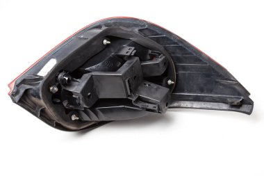 Siyah plastikten bir Alman arabasının fren lambasının arka tarafındaki beyaz izole bir arka plana monte edilmiş fren ışıkları. Araba tamirhanesinde yedek parça..