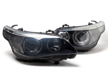 Bir Alman oto-optik ekipmanı için bir çift ksenon far. Beyaz izole bir arka planda lens ve düzeltici var. Bir araba servisinin ön vücut parçasını değiştirmek için yedek parça.
